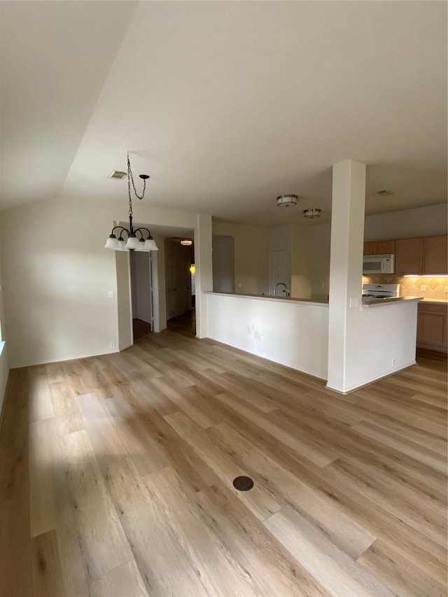 3006 Red Stag Pass, Missouri City, TX 77459 - unfurnished living room with a notable chandelier, vaulted ceiling, visible vents, and light wood-style floors