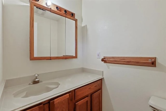 bathroom featuring toilet, visible vents, and vanity