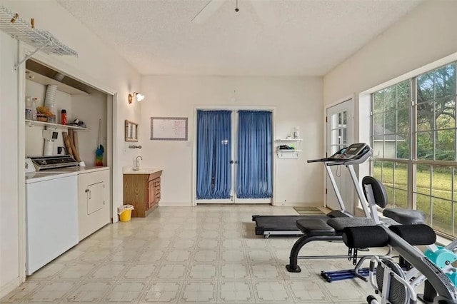 workout area with independent washer and dryer, a textured ceiling, french doors, baseboards, and light floors