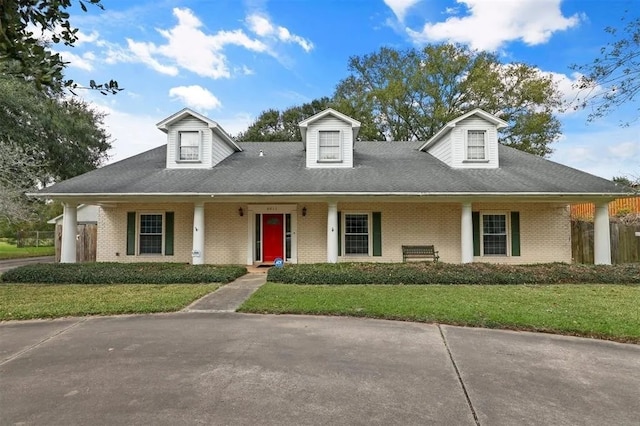 view of front of home with brick siding, fence, and a front lawn