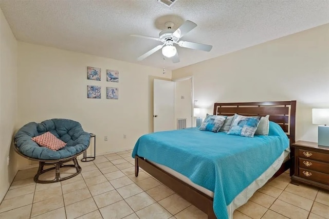 bedroom with visible vents, a textured ceiling, ceiling fan, and light tile patterned flooring