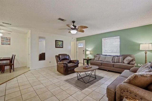 living area with visible vents, a ceiling fan, and light tile patterned floors