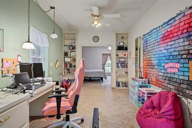 carpeted office featuring a ceiling fan and built in shelves