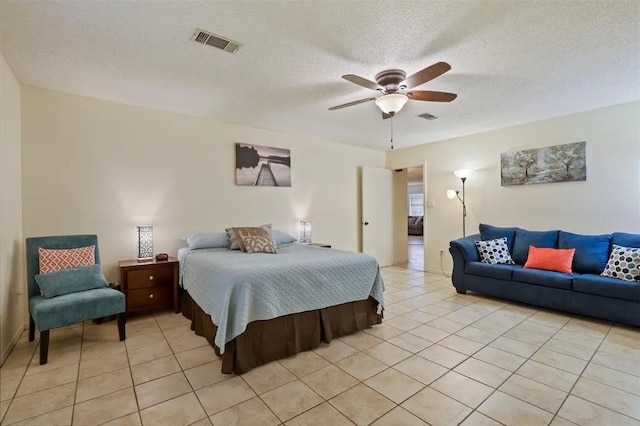 bedroom with a textured ceiling, ceiling fan, visible vents, and light tile patterned floors