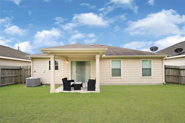 back of house with a fenced backyard, central air condition unit, a lawn, and a patio