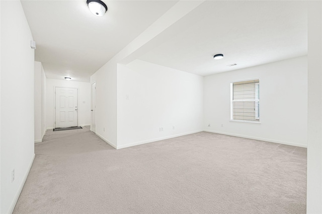 spare room with baseboards, visible vents, and light colored carpet
