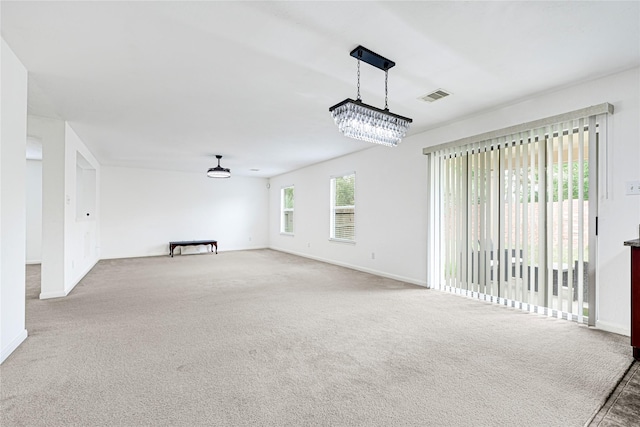 unfurnished living room featuring visible vents, carpet, and baseboards
