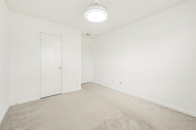 unfurnished bedroom featuring baseboards, visible vents, and carpet