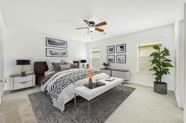 bedroom with baseboards, light carpet, a ceiling fan, and visible vents