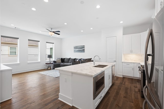 kitchen featuring recessed lighting, a sink, white cabinets, and stainless steel appliances