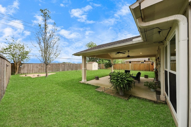 view of yard featuring a storage shed, an outdoor structure, a fenced backyard, and a patio area