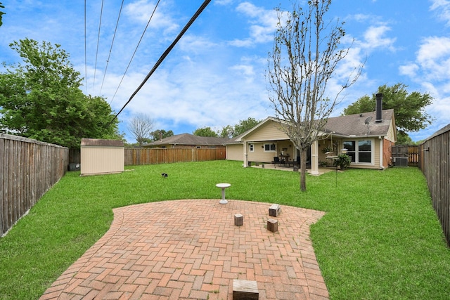 view of yard with a patio, a fenced backyard, a shed, and an outdoor structure