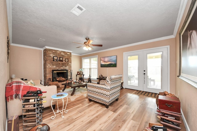 living area with visible vents, wood finished floors, a textured ceiling, french doors, and a ceiling fan