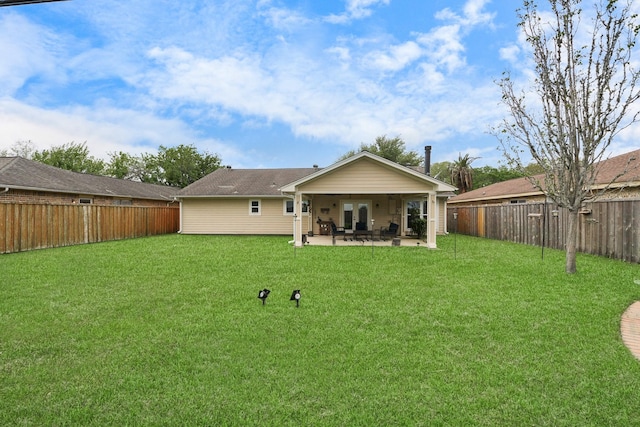 back of house featuring a lawn, a fenced backyard, and a patio area