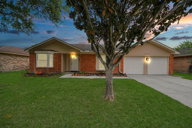 ranch-style home with brick siding, an attached garage, a lawn, and concrete driveway