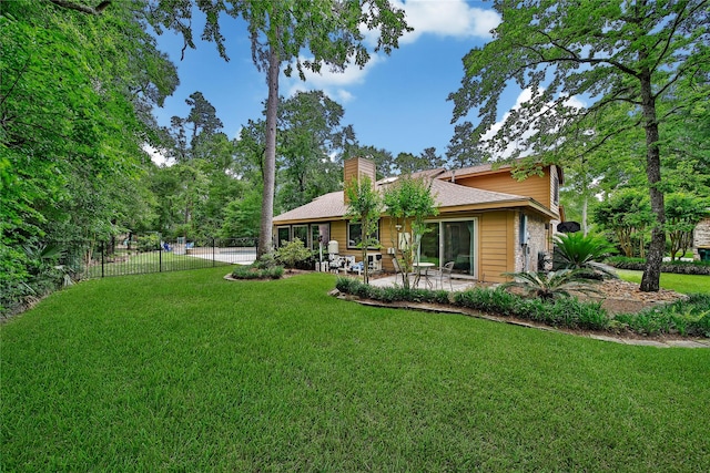 back of property featuring a lawn, fence, a patio, and a chimney