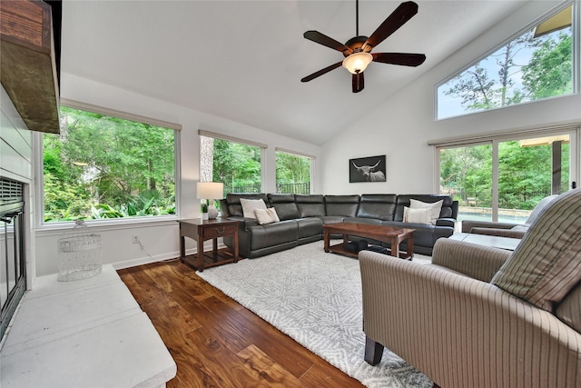 living room featuring dark wood-style flooring, a ceiling fan, and high vaulted ceiling