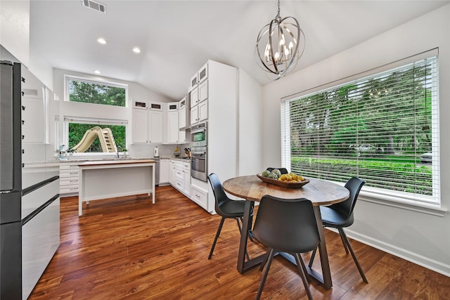 dining room featuring dark wood-style flooring, visible vents, vaulted ceiling, baseboards, and a notable chandelier