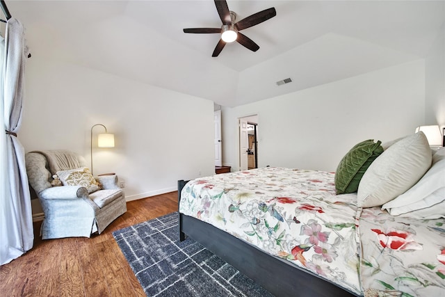 bedroom featuring visible vents, wood finished floors, baseboards, a ceiling fan, and vaulted ceiling