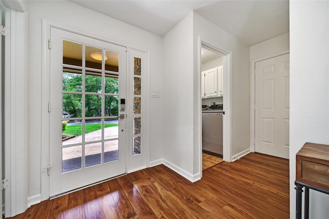 doorway to outside featuring washer / dryer, baseboards, and dark wood-style floors