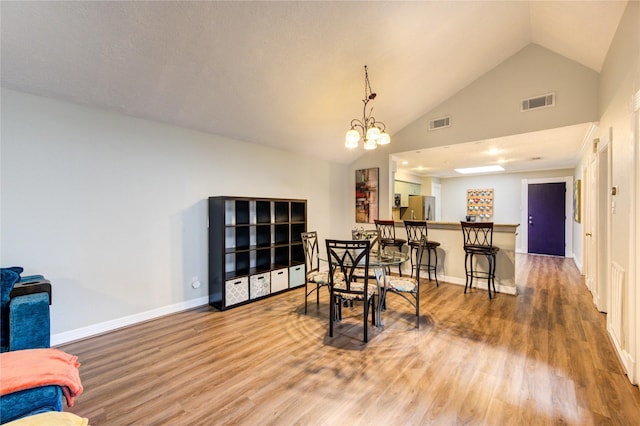 dining space with baseboards, a chandelier, wood finished floors, and visible vents