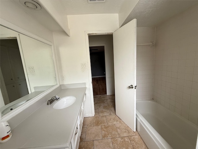 bathroom featuring shower / bath combination, vanity, stone finish floor, and visible vents
