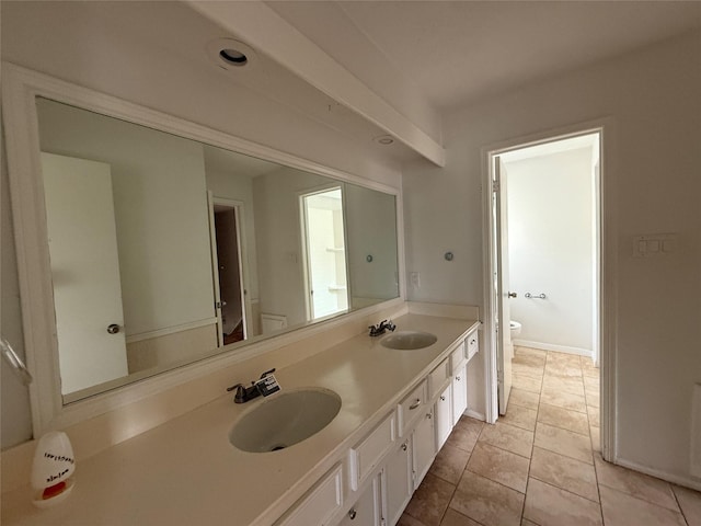 bathroom featuring double vanity, a sink, tile patterned floors, and toilet