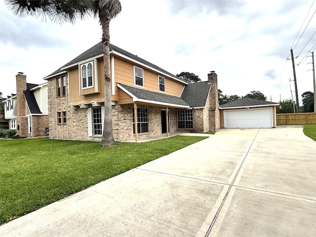 view of front of property featuring a detached garage, brick siding, fence, and a front yard