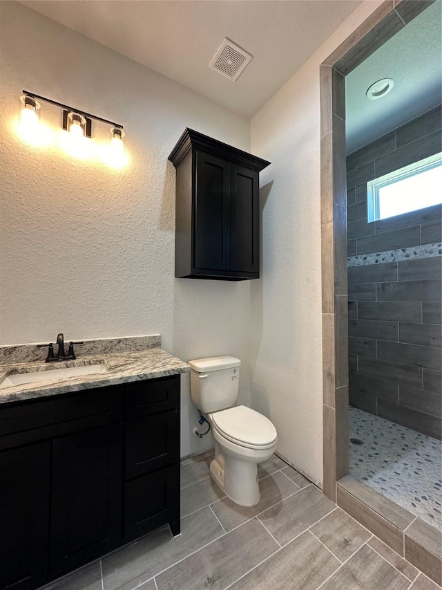 507 Kickapoo Dr, Anahuac, TX 77514 - full bath with visible vents, vanity, toilet, and tiled shower