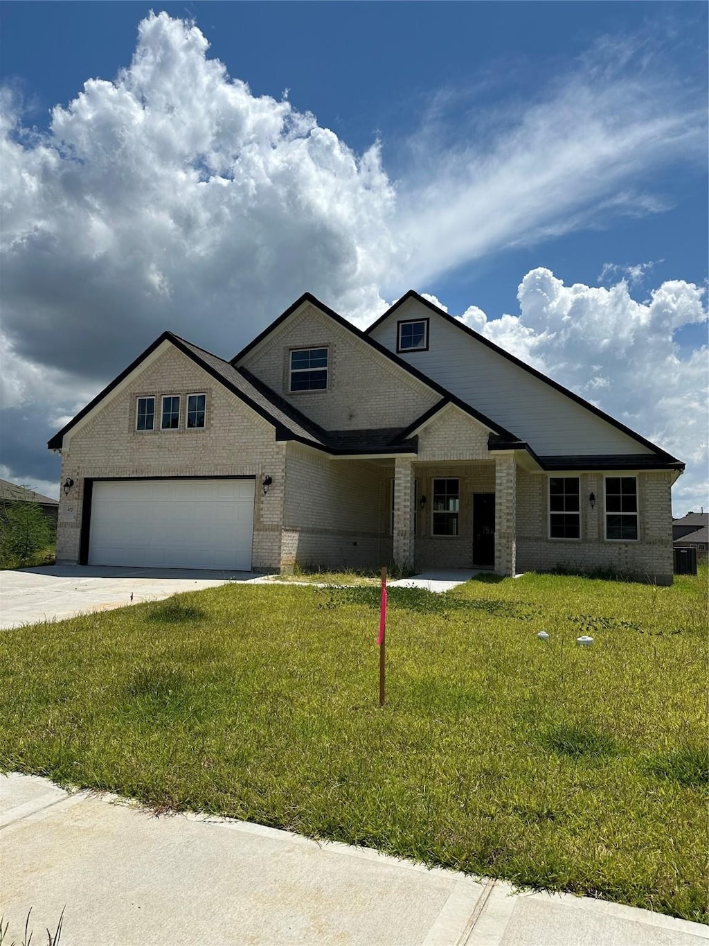 507 Kickapoo Dr, Anahuac, TX 77514 - view of front of home featuring concrete driveway, a front lawn, and brick siding