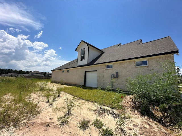 507 Kickapoo Dr, Anahuac, TX 77514 - view of side of property with brick siding and a shingled roof