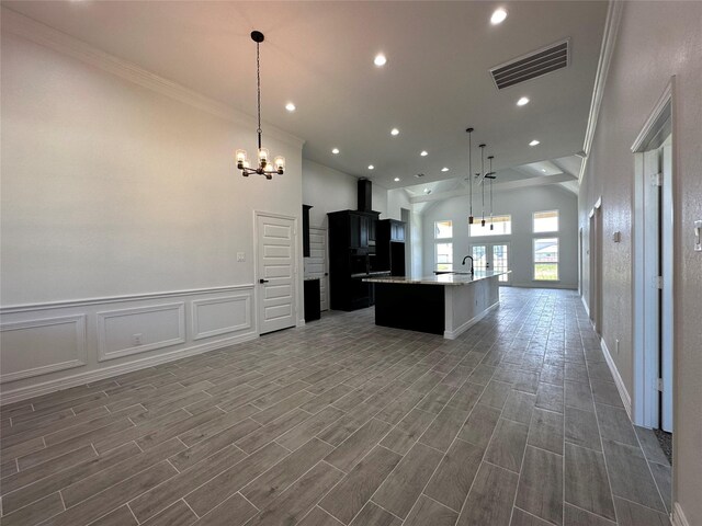 507 Kickapoo Dr, Anahuac, TX 77514 - kitchen featuring a kitchen island with sink, visible vents, crown molding, open floor plan, and an inviting chandelier