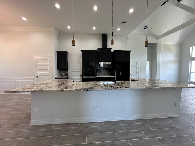 507 Kickapoo Dr, Anahuac, TX 77514 - kitchen featuring ornamental molding, oven, a spacious island, stainless steel microwave, and dark cabinetry