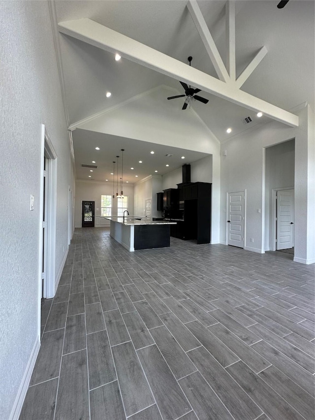 507 Kickapoo Dr, Anahuac, TX 77514 - unfurnished living room featuring ceiling fan, beam ceiling, high vaulted ceiling, baseboards, and dark wood-type flooring