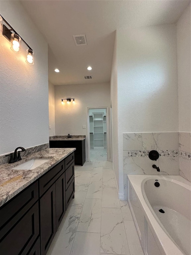 507 Kickapoo Dr, Anahuac, TX 77514 - full bath with a walk in closet, vanity, marble finish floor, visible vents, and a garden tub