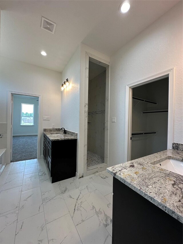507 Kickapoo Dr, Anahuac, TX 77514 - bathroom with a sink, visible vents, a tile shower, and two vanities