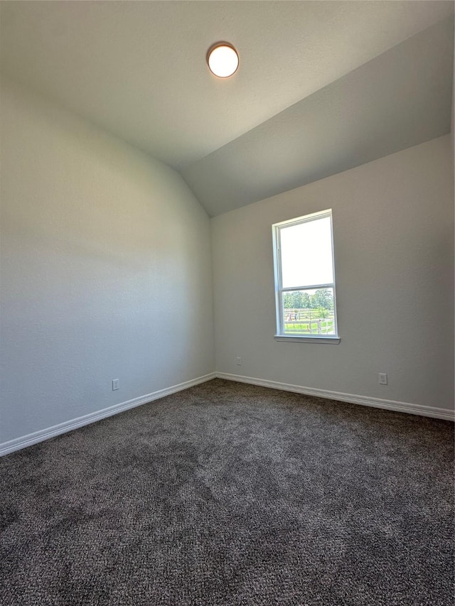 507 Kickapoo Dr, Anahuac, TX 77514 - unfurnished room with baseboards, vaulted ceiling, and dark colored carpet