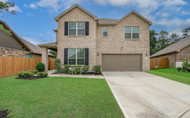 view of front of property with driveway, a front yard, a garage, brick siding, and fence
