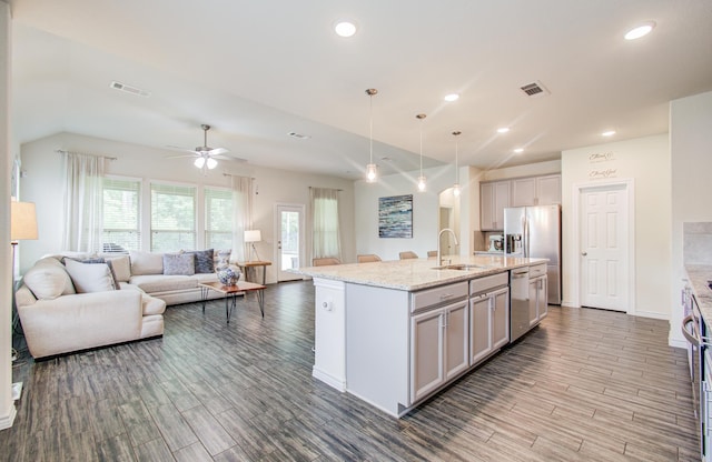 kitchen featuring a sink, stainless steel appliances, open floor plan, wood finished floors, and visible vents