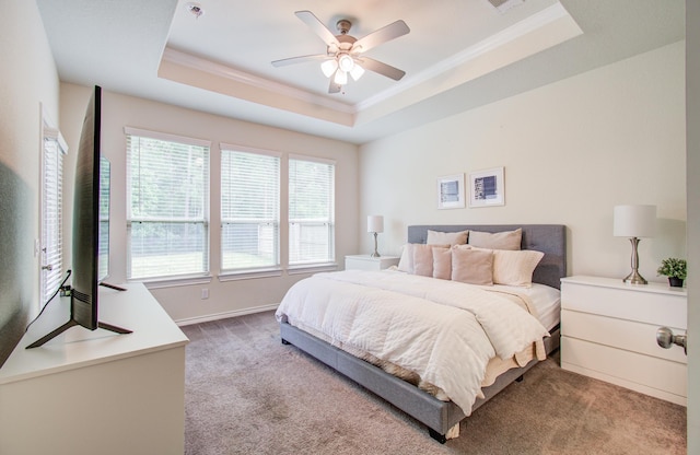 bedroom with crown molding, a ceiling fan, carpet flooring, and a raised ceiling