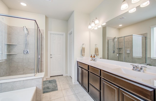 full bath with a sink, tile patterned flooring, double vanity, a shower stall, and visible vents