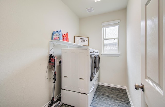 laundry room with laundry area, independent washer and dryer, visible vents, wood finished floors, and baseboards