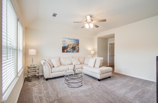 carpeted living area with visible vents, baseboards, ceiling fan, and a wealth of natural light