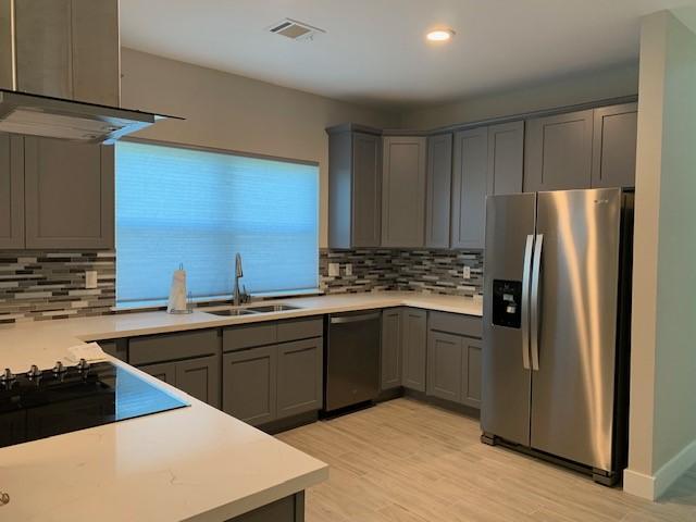 1019 E 37th St, Houston, TX 77022 - kitchen featuring a sink, gray cabinets, stainless steel refrigerator with ice dispenser, and dishwashing machine