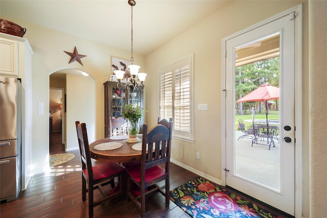 13882 Oak Manor Dr, Willis, TX 77318 - dining area featuring an inviting chandelier, arched walkways, dark wood finished floors, and a wealth of natural light