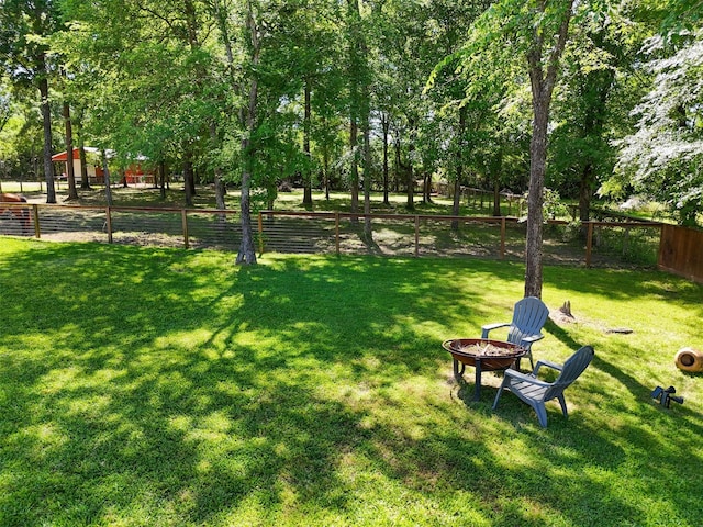 13882 Oak Manor Dr, Willis, TX 77318 - surrounding community featuring fence, a lawn, and an outdoor fire pit