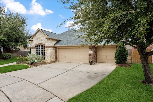 28406 Green Mill Ct, Spring, TX 77386 - french country style house featuring a garage, a front lawn, fence, a shingled roof, and driveway