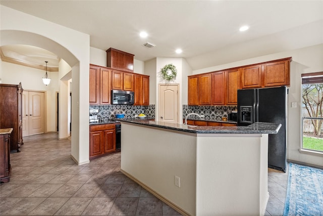 28406 Green Mill Ct, Spring, TX 77386 - kitchen featuring decorative backsplash, visible vents, black fridge with ice dispenser, stainless steel microwave, and an island with sink