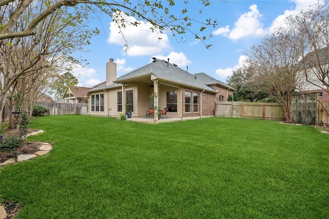 28406 Green Mill Ct, Spring, TX 77386 - back of house featuring ceiling fan, a patio, a fenced backyard, a chimney, and a yard