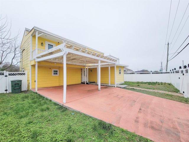 5703 Fraser Ave, Galveston, TX 77551 - view of patio with a fenced backyard, a balcony, driveway, and a carport
